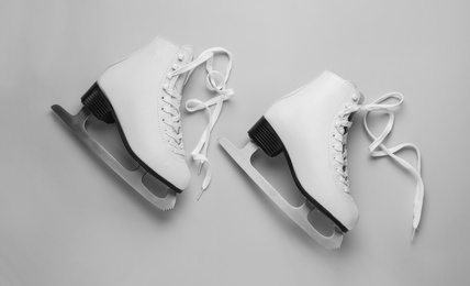 Photo of Pair of figure ice skates on light grey background, flat lay