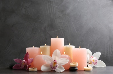 Photo of Beautiful composition with lit candles and flowers on table