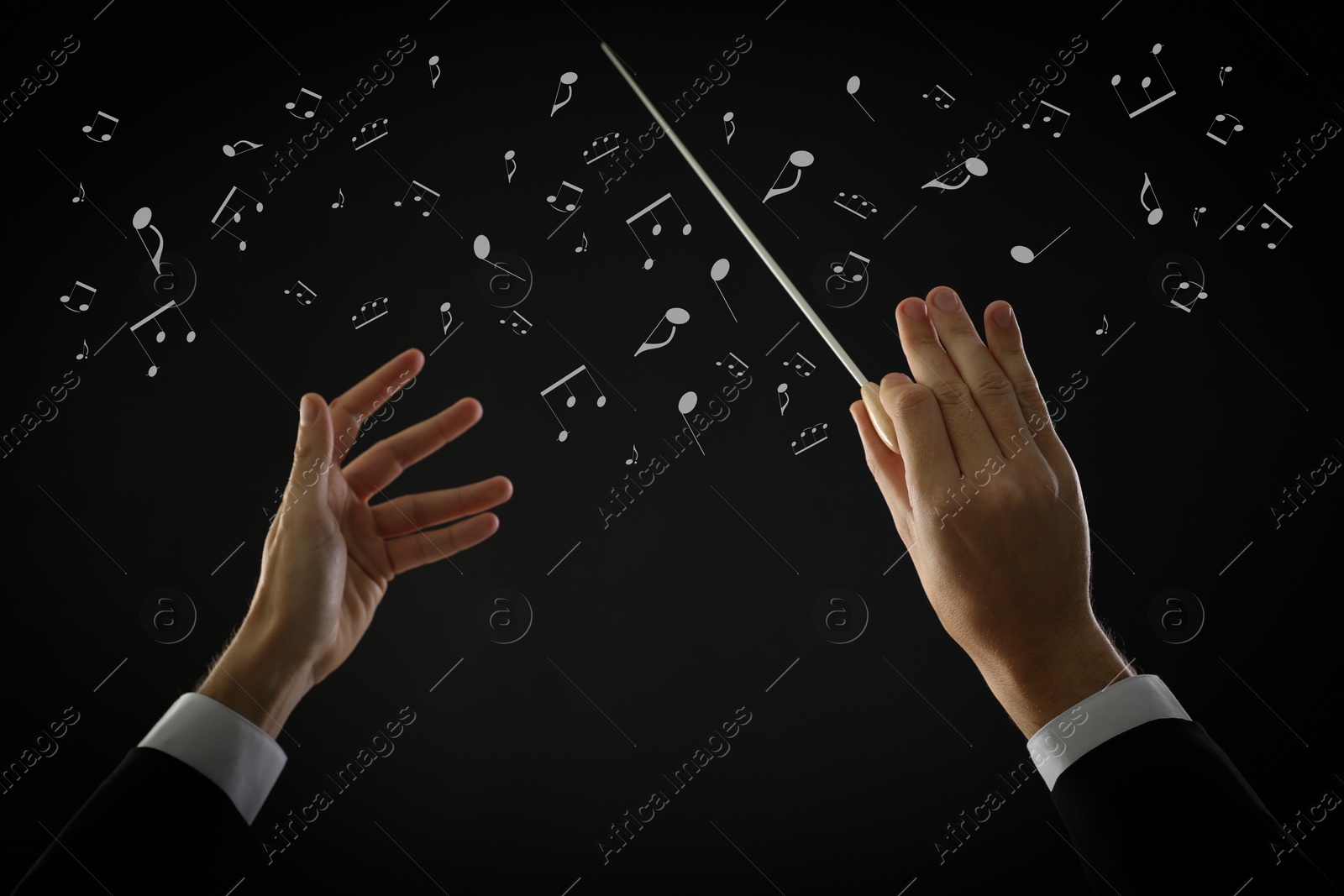 Image of Conductor with baton and music notes on dark background, closeup