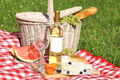 Picnic blanket with delicious food and wine outdoors on summer day