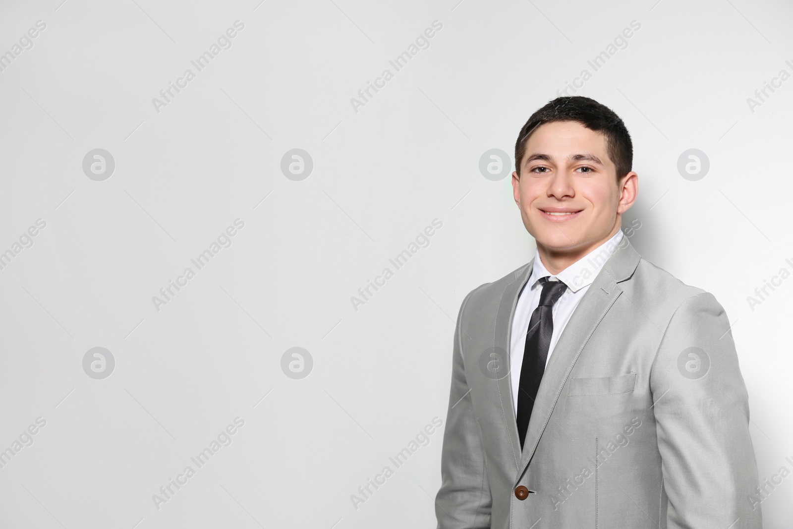 Photo of Portrait of young businessman on light background. Space for text