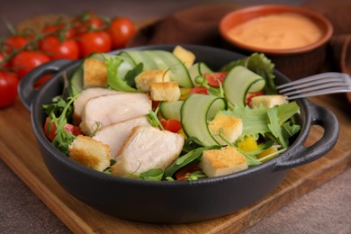 Photo of Delicious salad with croutons, chicken and vegetables served on grey table, closeup