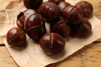 Fresh edible sweet chestnuts on wooden table, closeup