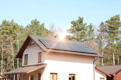 Photo of House with installed solar panels on roof. Alternative energy