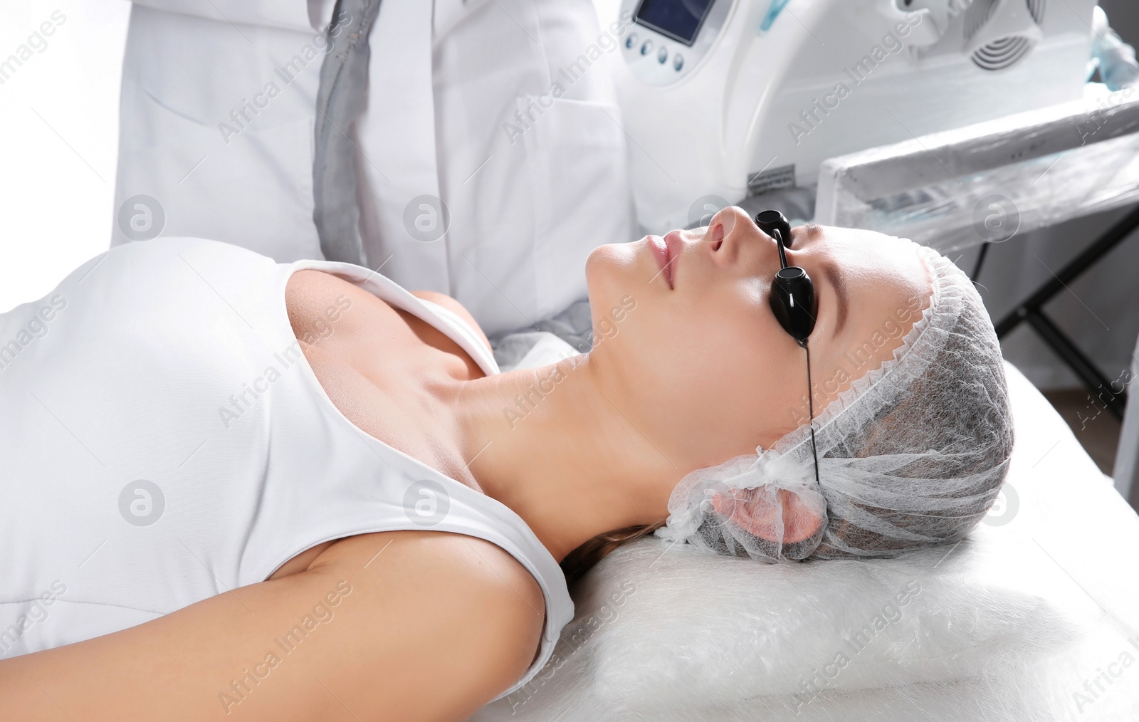 Photo of Young woman undergoing laser removal of permanent makeup in salon. Eyebrow correction