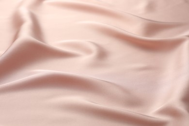 Photo of Crumpled pink silk fabric as background, closeup