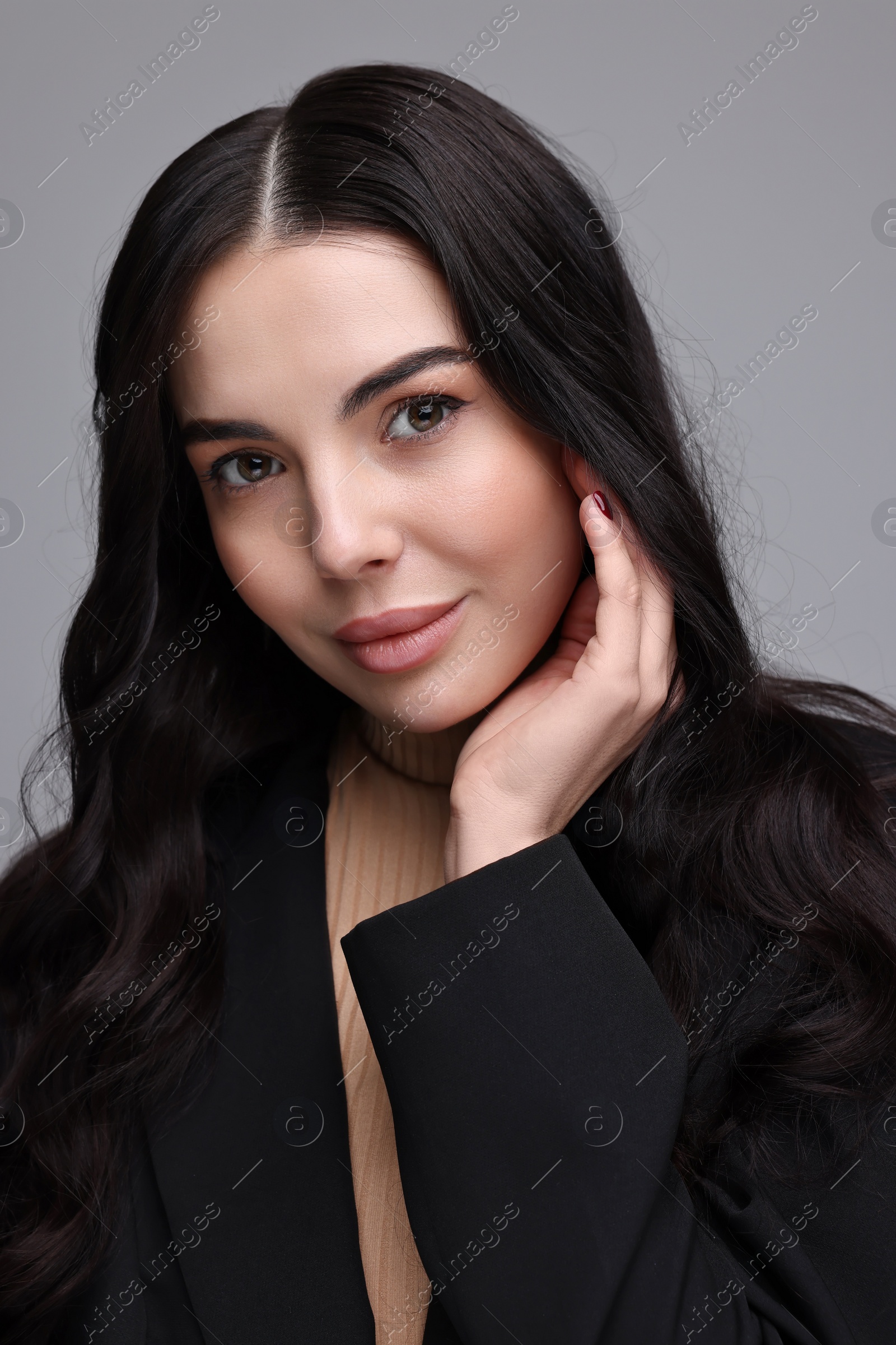 Photo of Beautiful woman in black jacket on gray background