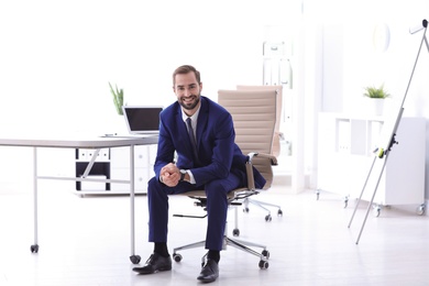 Photo of Young businessman sitting in comfortable office chair at workplace