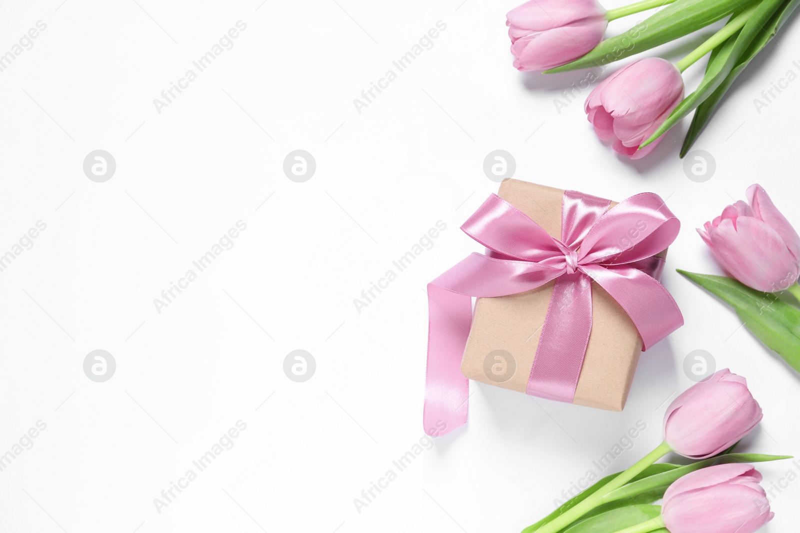 Photo of Beautiful gift box and tulips on white background, flat lay. Space for text