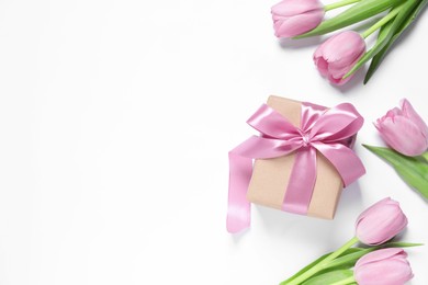 Photo of Beautiful gift box and tulips on white background, flat lay. Space for text