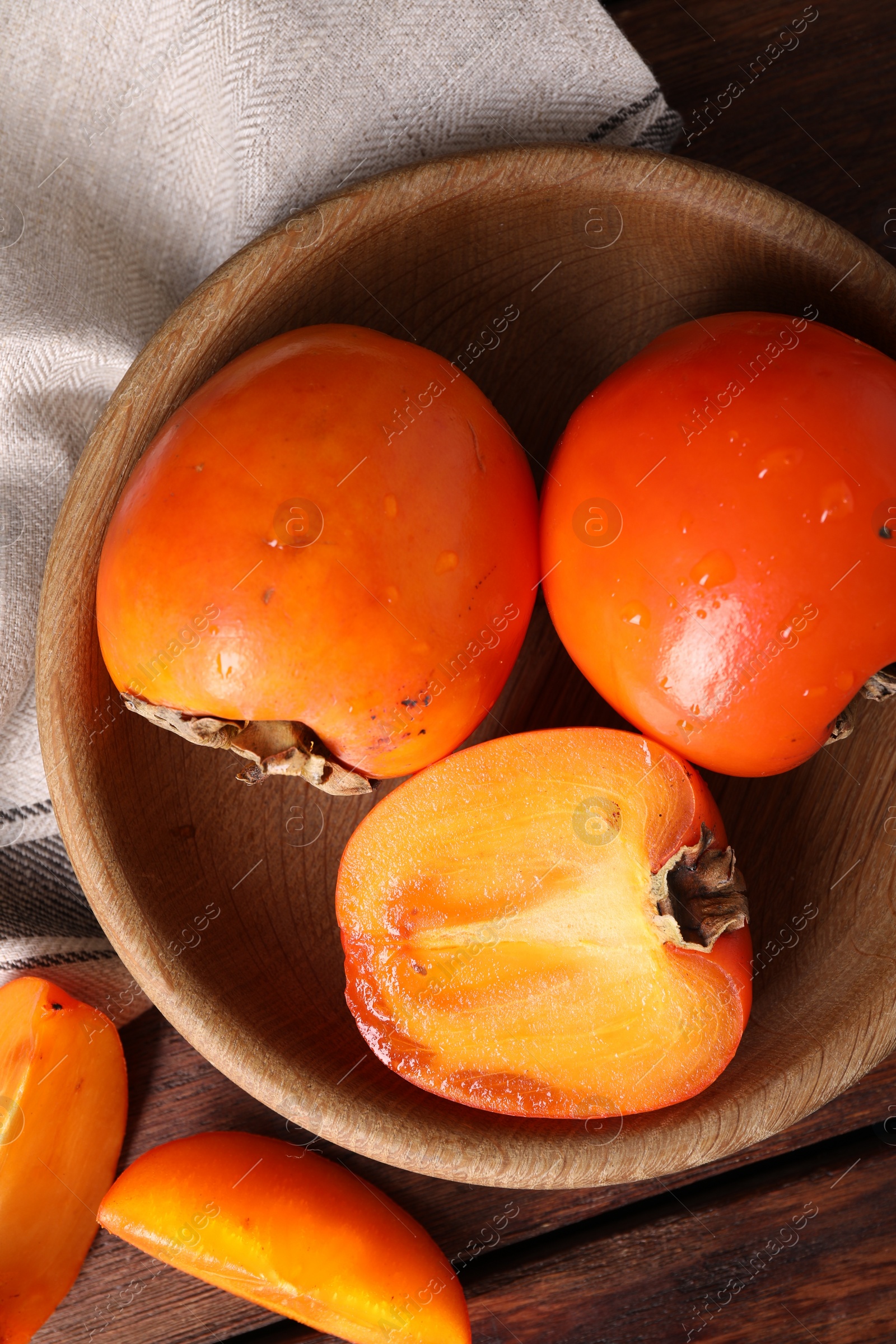 Photo of Delicious ripe persimmons on wooden table, top view