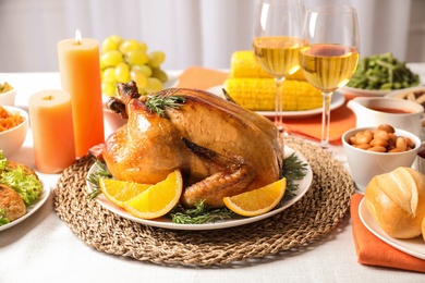 Photo of Delicious roasted turkey with garnish on dinner table