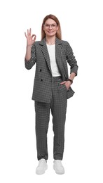 Photo of Beautiful happy businesswoman in suit showing ok gesture on white background