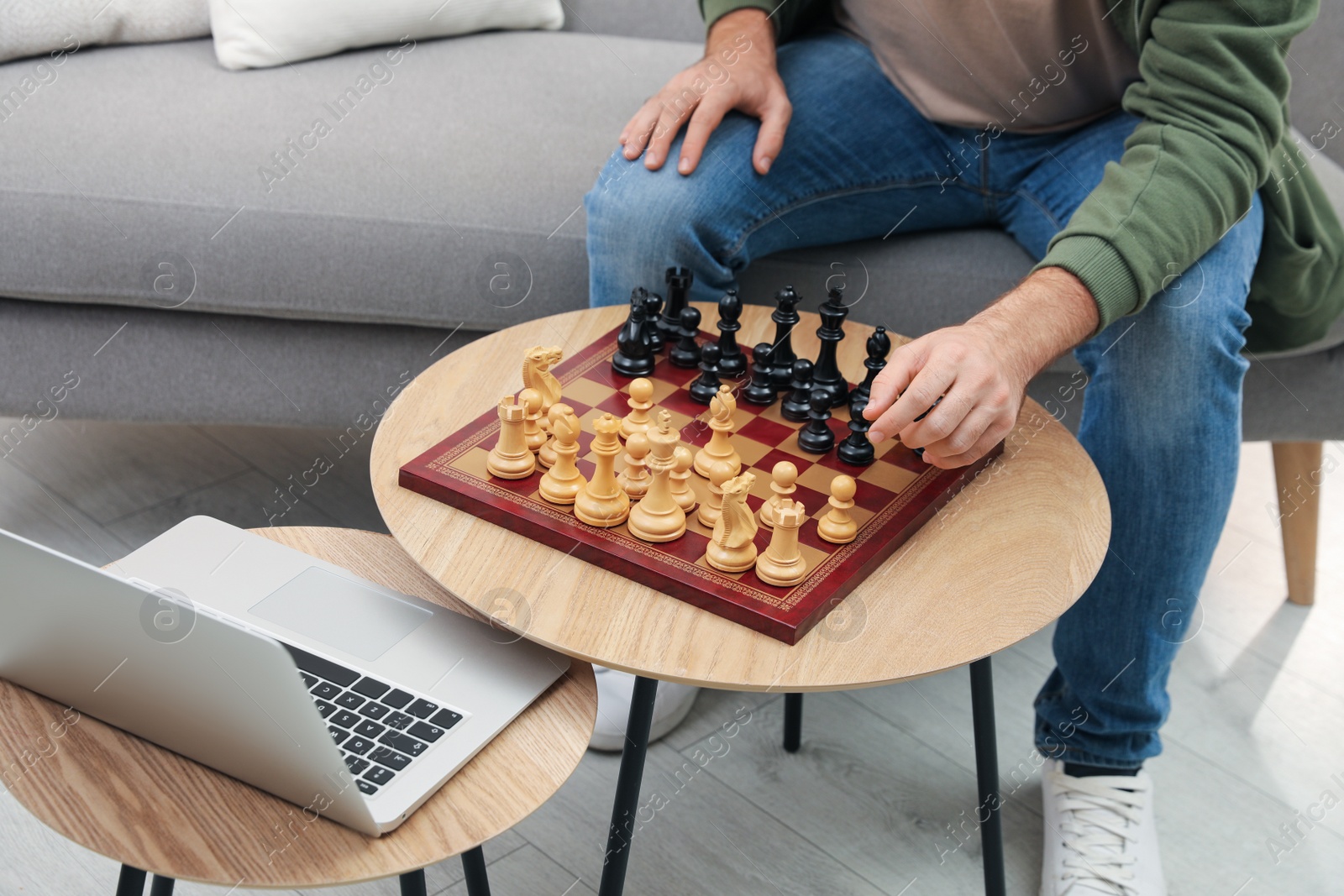 Photo of Man playing chess with partner through online video chat in living room, closeup