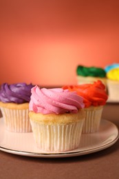 Photo of Delicious cupcakes with bright cream on color background, space for text