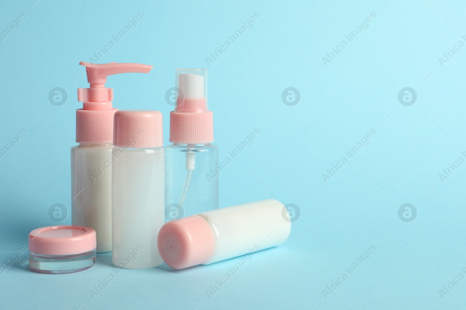 Photo of Cosmetic travel kit on light blue background. Bath accessories. Space for text