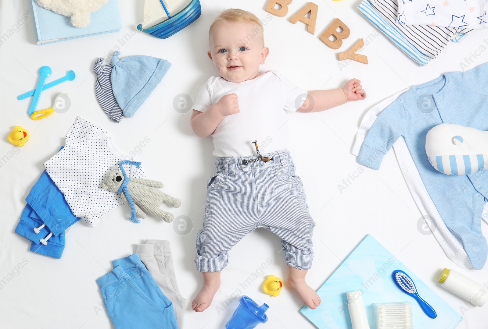 Photo of Cute little baby with clothing and accessories on white background, top view