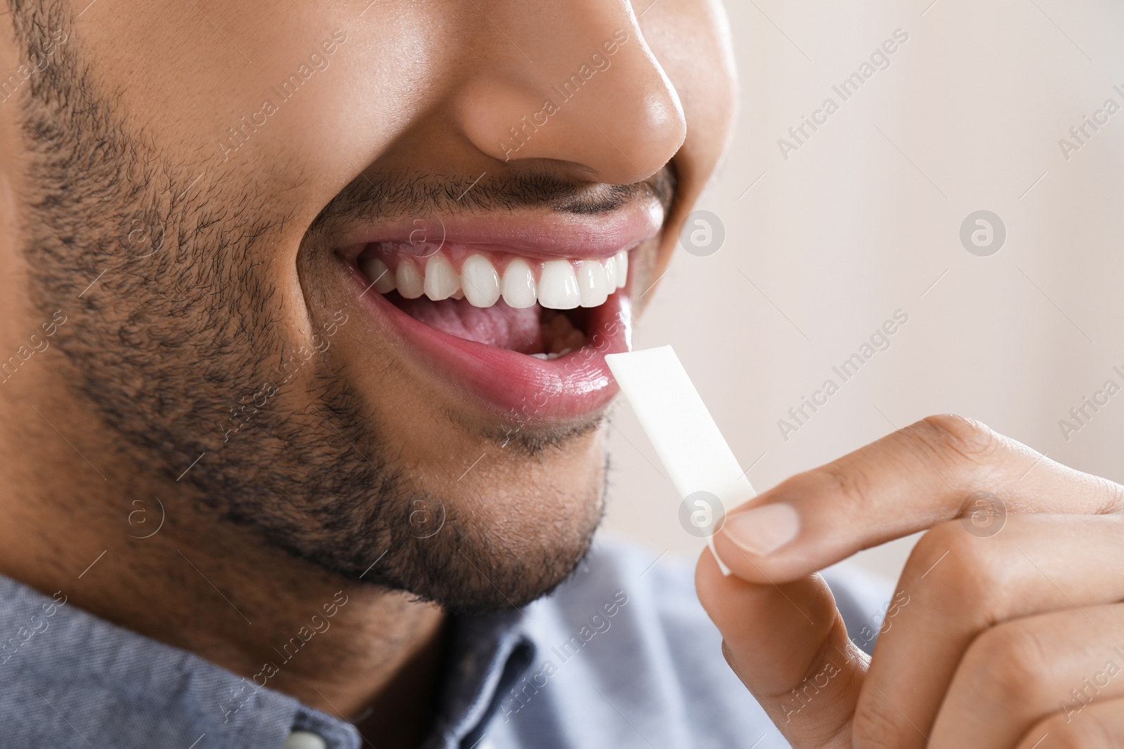 Photo of Man with chewing gum on blurred background, closeup