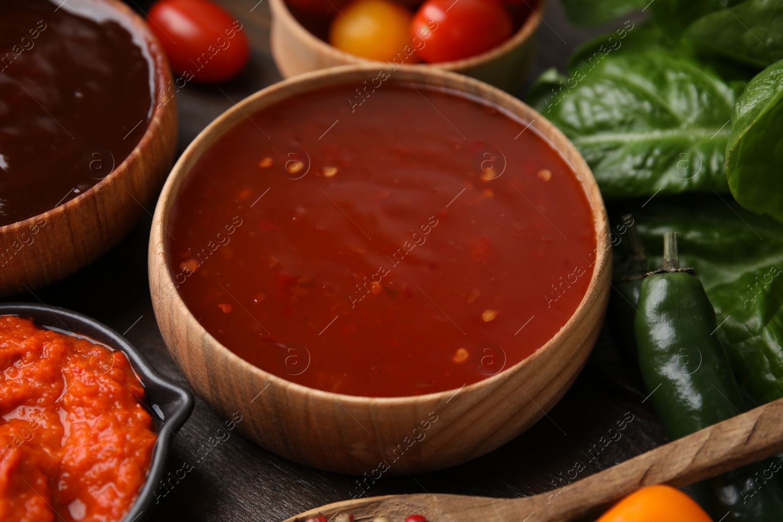 Photo of Homemade marinade in bowl on wooden table, closeup