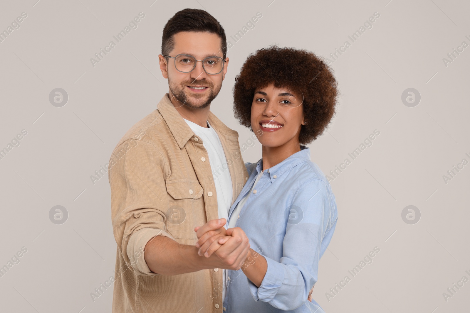 Photo of International dating. Happy couple dancing on light grey background