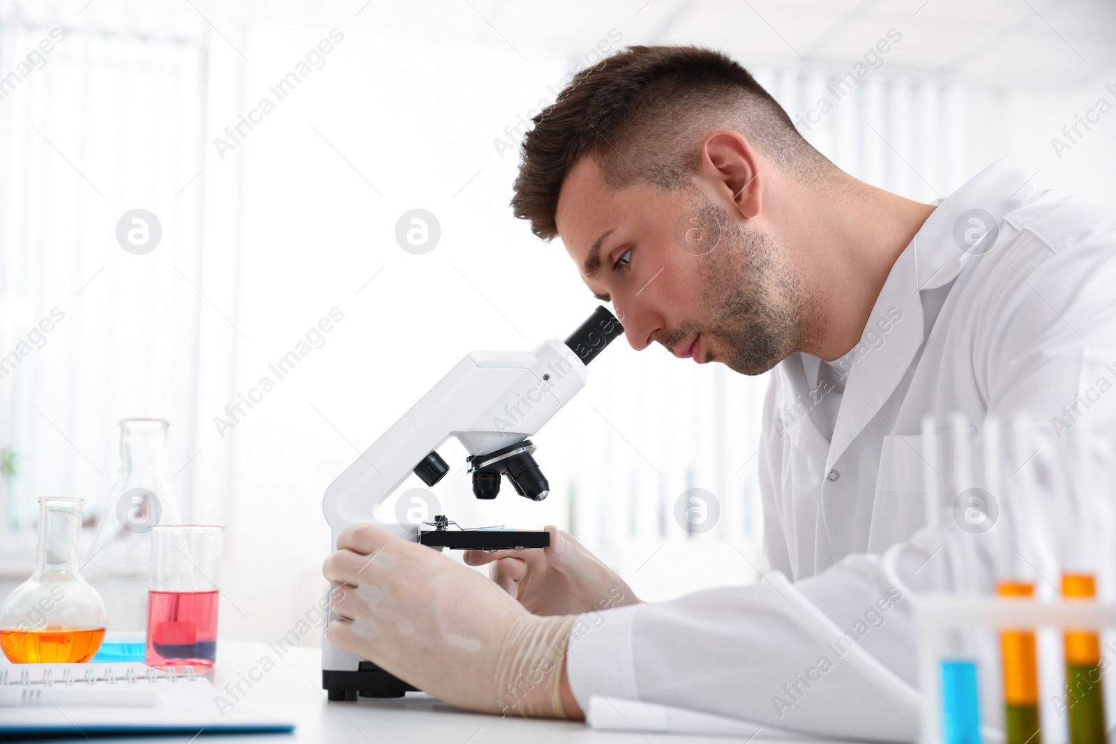 Photo of Scientist using modern microscope at table. Medical research