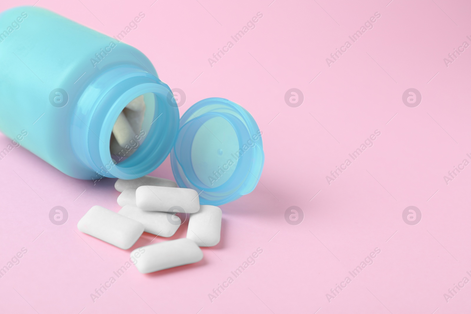 Photo of Jar with chewing gums on pink background, closeup. Space for text