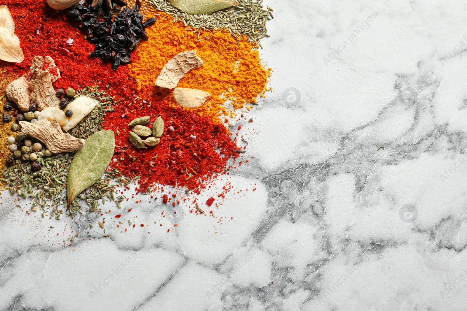 Photo of Different aromatic spices on marble background, top view with space for text