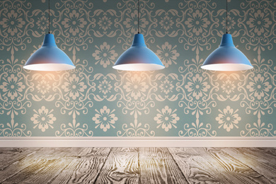 Image of Blue patterned wallpaper and glowing hanging lamps in room
