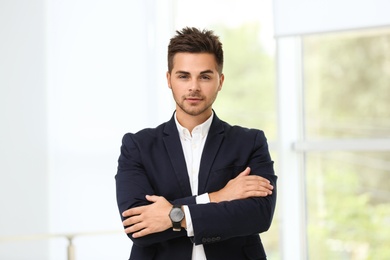 Portrait of handsome young man in elegant suit indoors