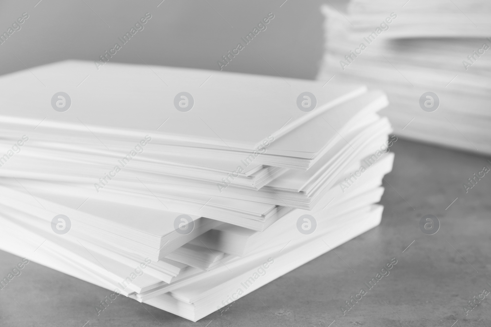 Photo of Stack of blank paper on grey stone table