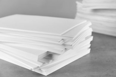 Photo of Stack of blank paper on grey stone table