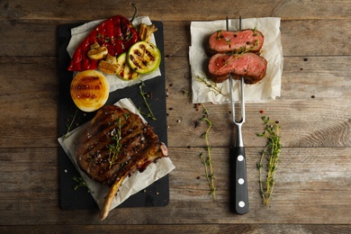 Flat lay composition with grilled meat on wooden table