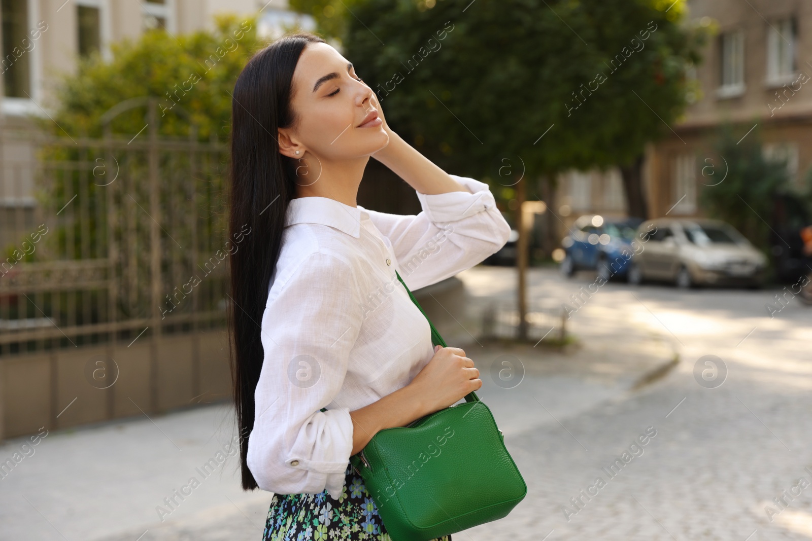 Photo of Beautiful young woman with stylish bag on city street