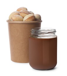 Jar with boiled condensed milk and walnut shaped cookies on white background