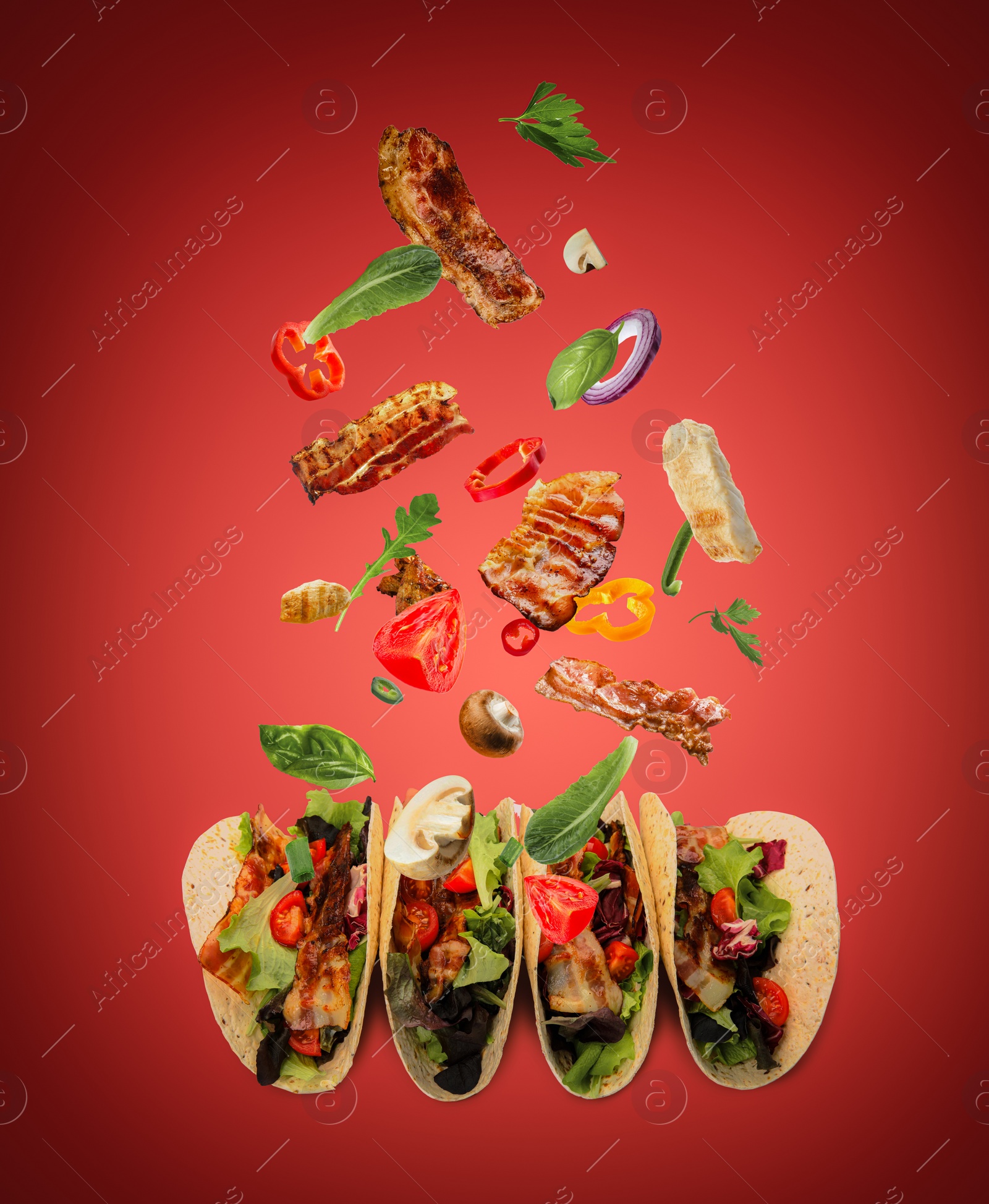 Image of Delicious tacos. Ingredients falling into tortillas on red background