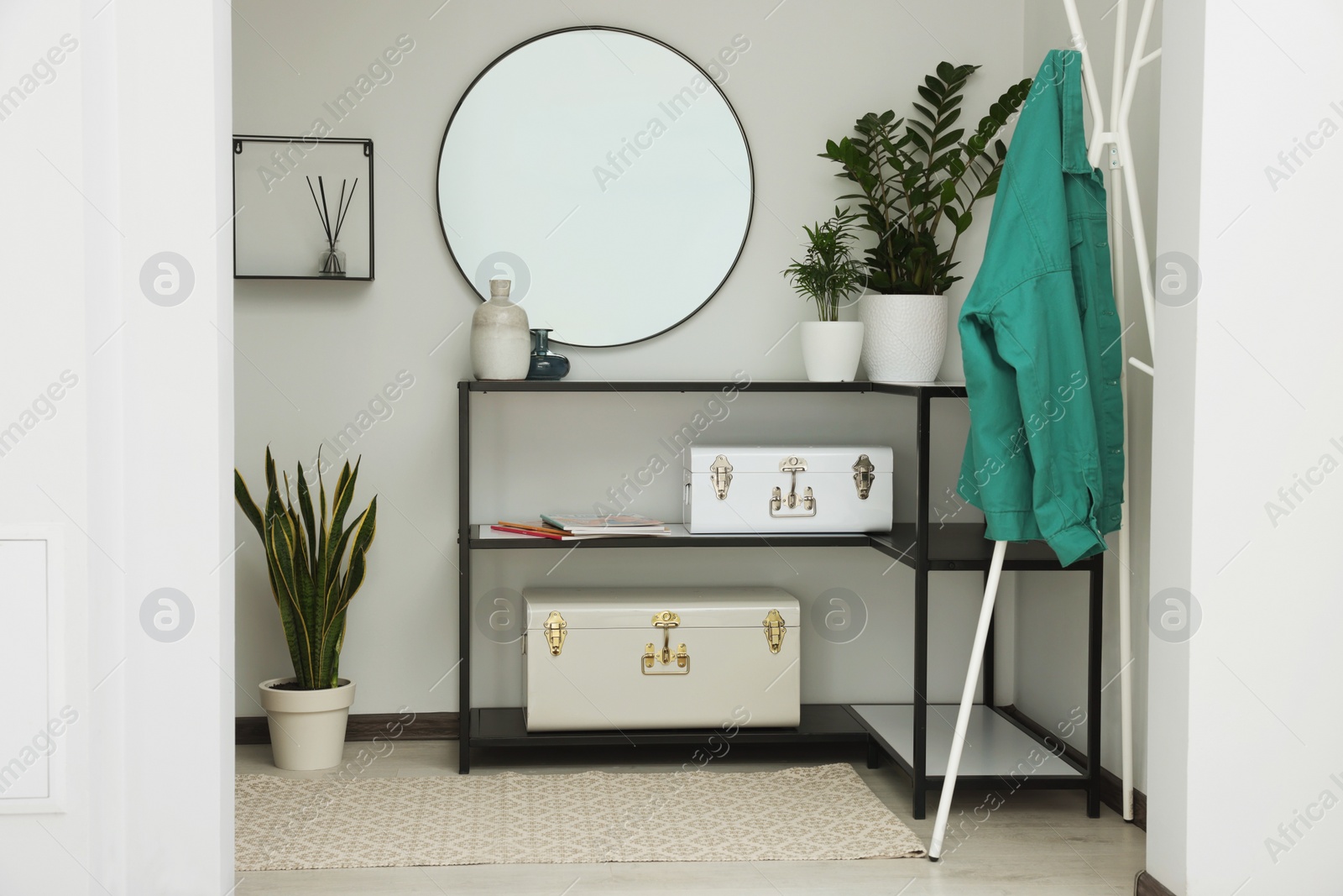 Photo of Stylish hallway interior with round mirror and rack