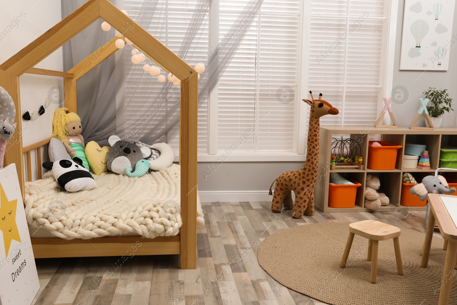 Photo of Cute child's room interior with toys and wooden furniture