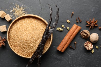 Photo of Different aromatic spices on dark textured table, flat lay