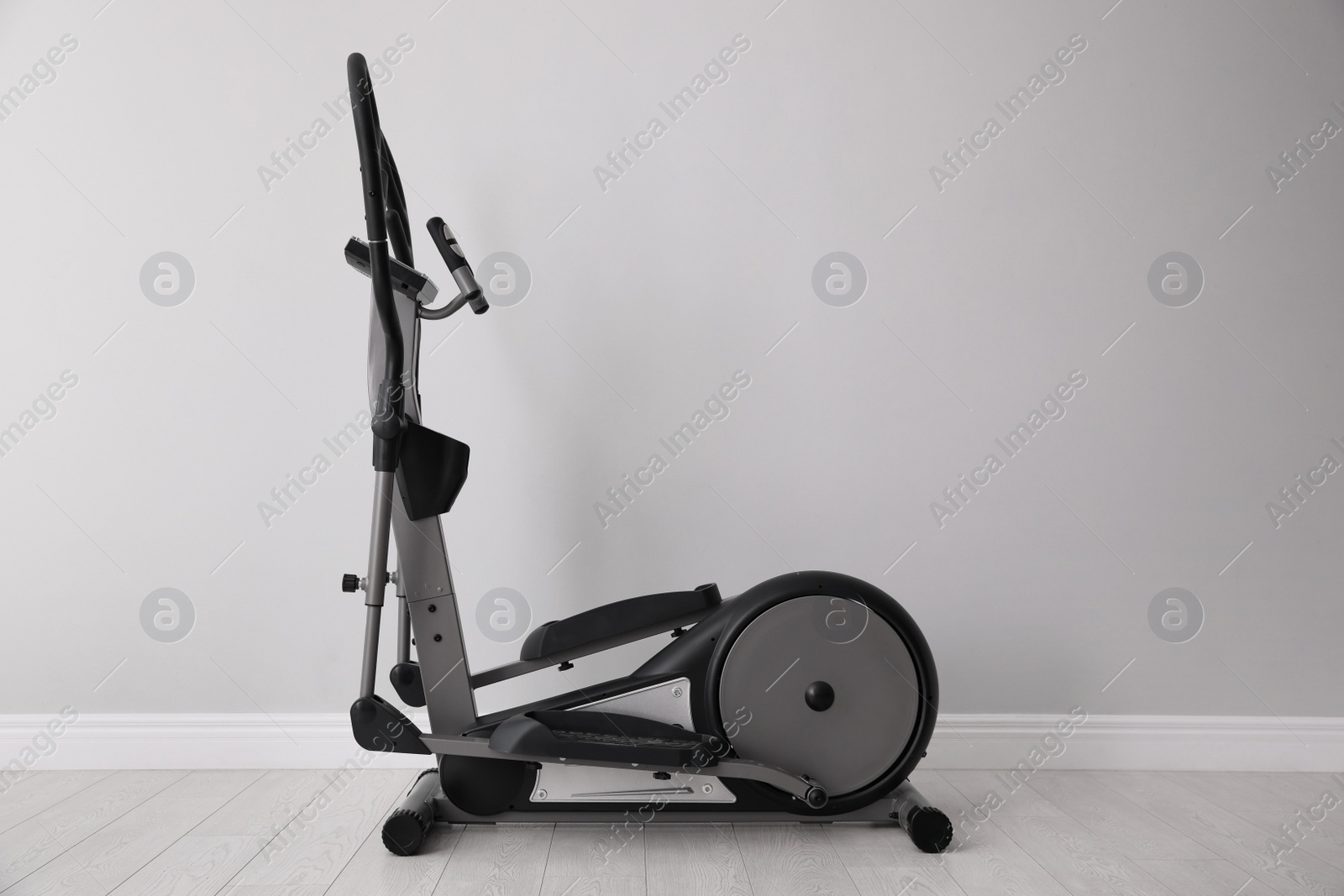 Photo of Elliptical machine cross trainer near light grey wall indoors