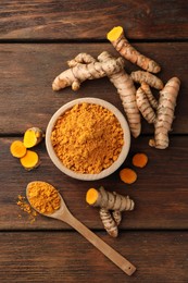 Photo of Aromatic turmeric powder and raw roots on wooden table, flat lay