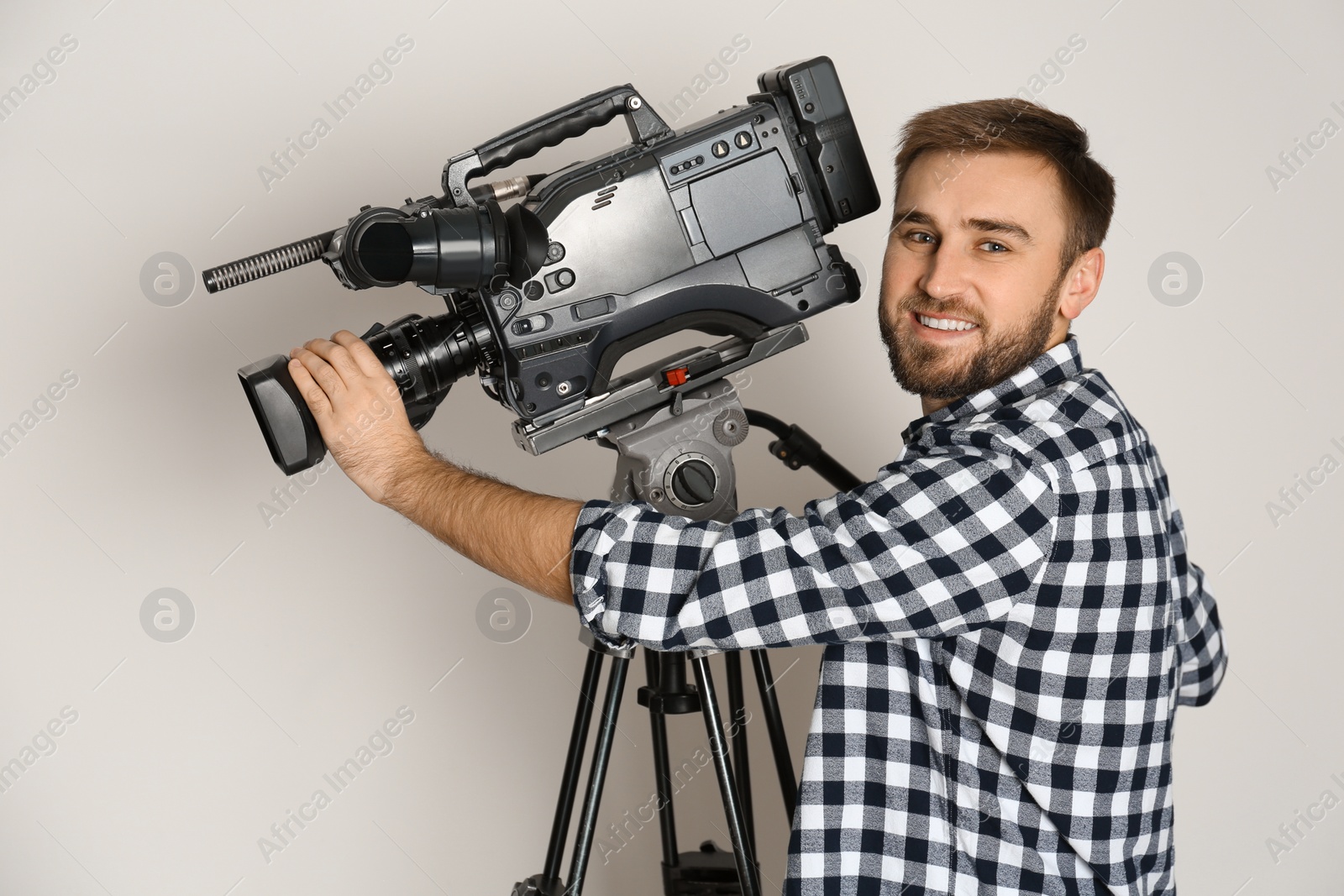 Photo of Operator with professional video camera on white background