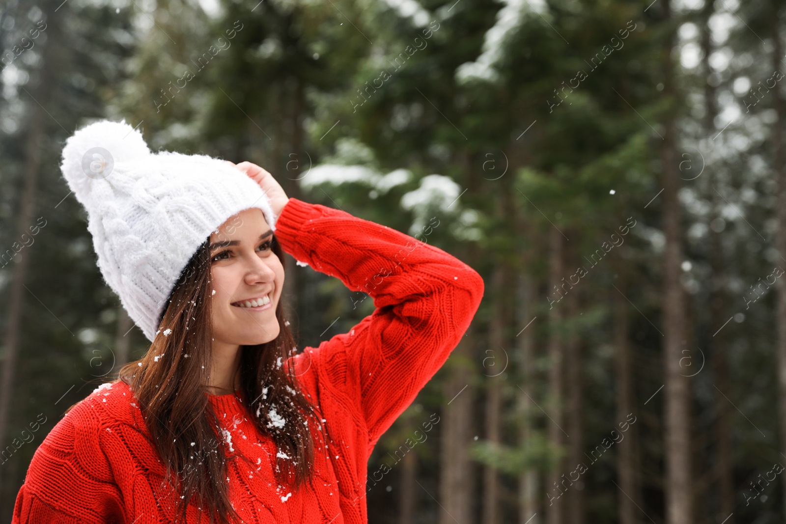 Photo of Young woman in warm sweater outdoors on snowy day, space for text. Winter vacation