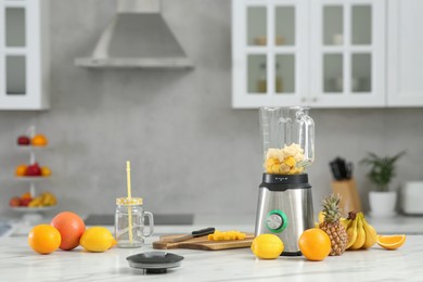 Blender with smoothie ingredients on white marble table. Space for text