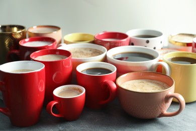 Photo of Many cups of different coffees on grey table