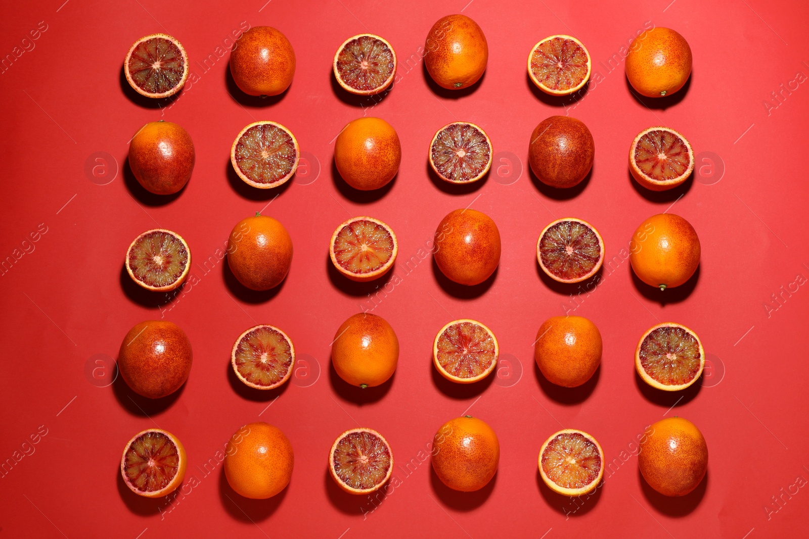 Photo of Many ripe sicilian oranges on red background, flat lay