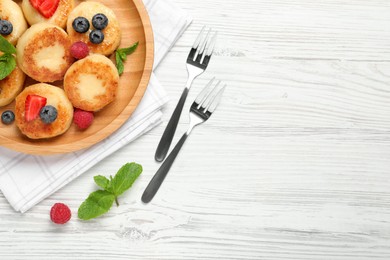 Photo of Delicious cottage cheese pancakes with fresh berries and honey on white wooden table, flat lay. Space for text