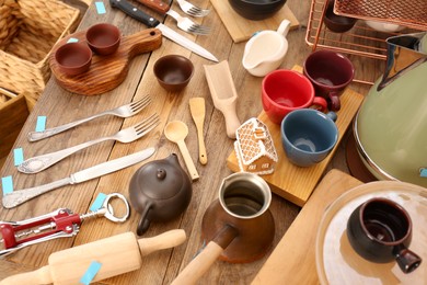 Many different cooking utensils on wooden table, above view. Garage sale
