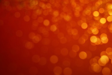 Photo of Blurred view of golden lights on red background. Bokeh effect