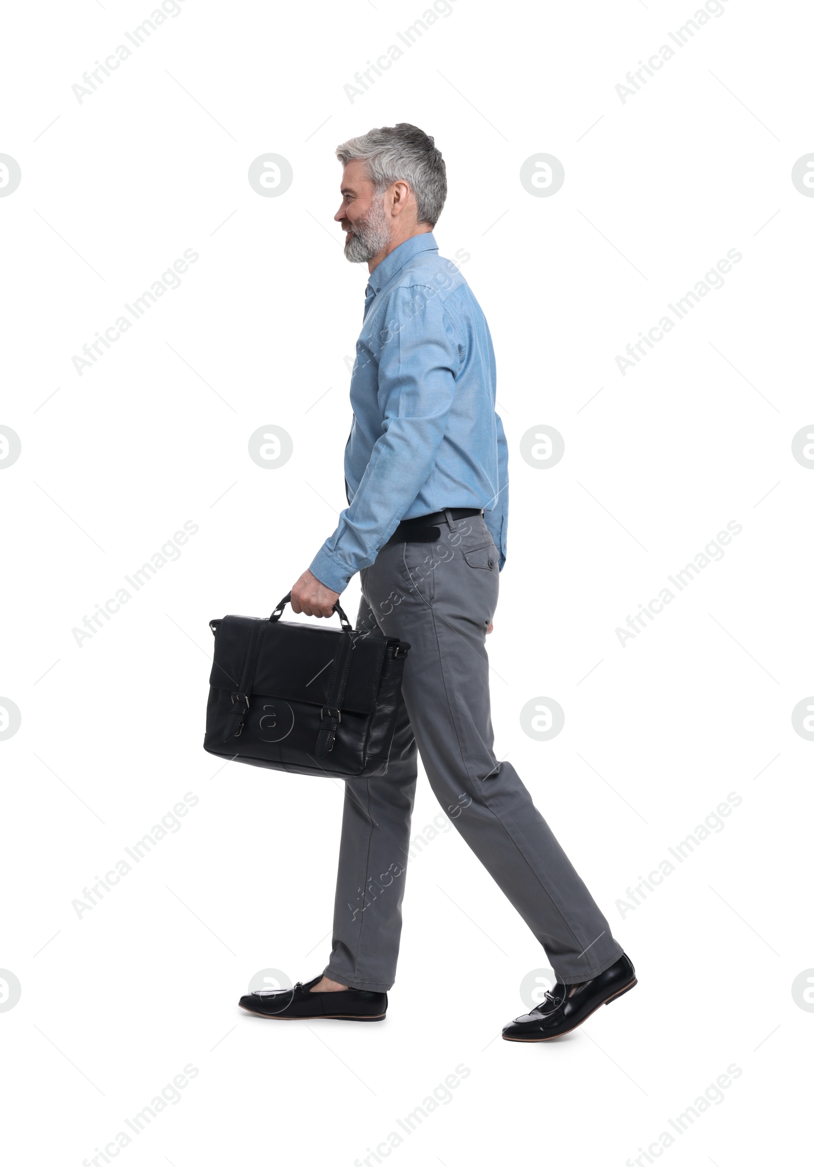 Photo of Mature businessman in stylish clothes with briefcase walking on white background
