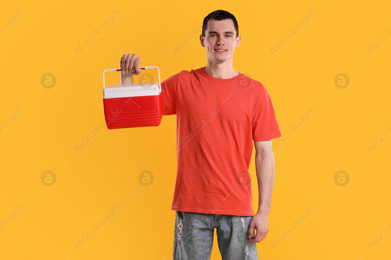 Photo of Man with red cool box on orange background